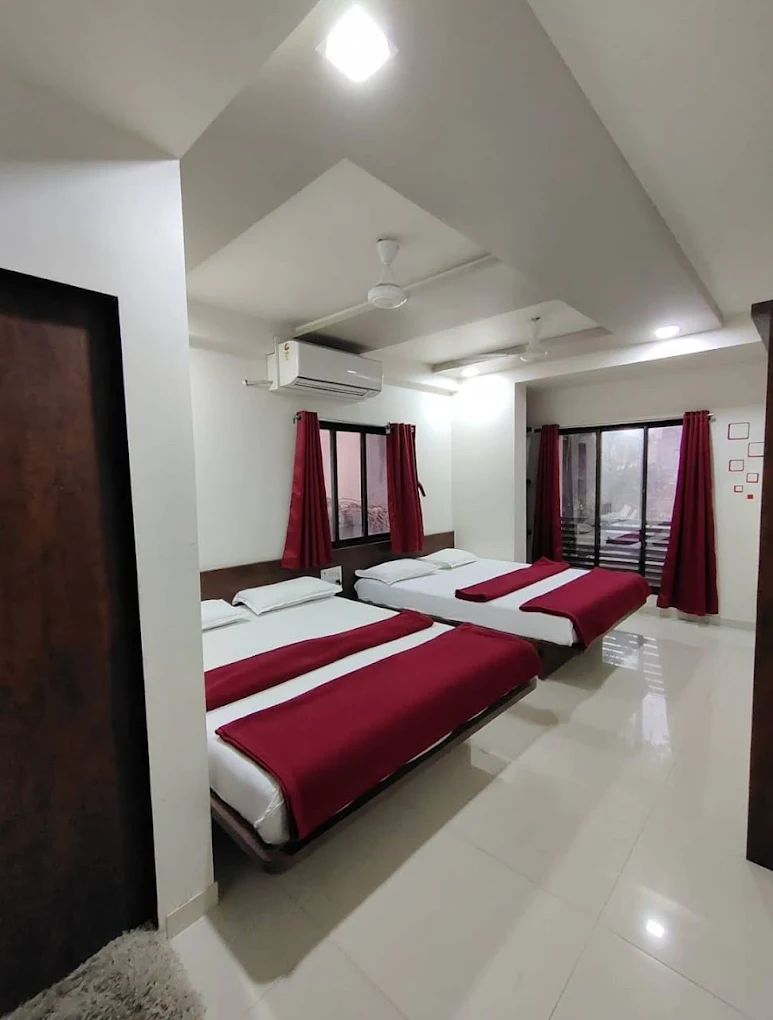 Family room with multiple beds at Karnataka Guest House